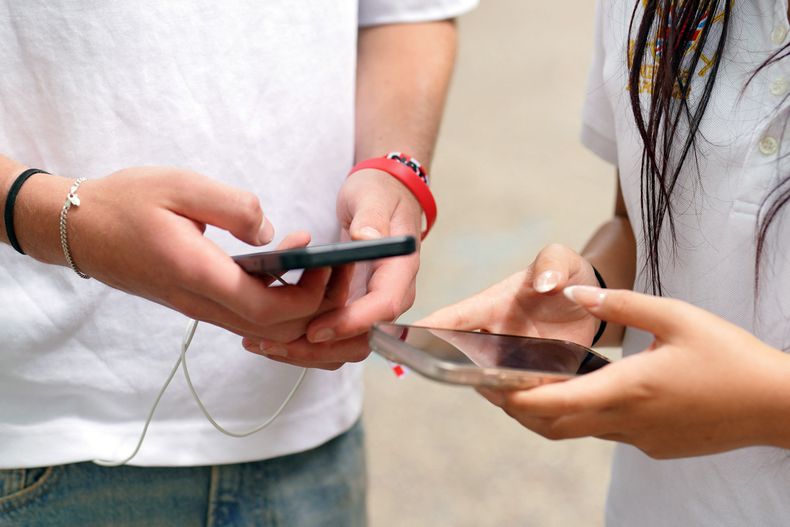 Adolescentes con celular.