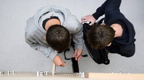 Alumnos guardan sus teléfonos celulares en sus taquillas tras apagarlos, durante una prueba en un colegio de Lorient, al oeste de Francia.