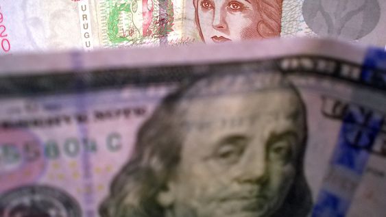 Billetes de dólares y pesos uruguayos.
