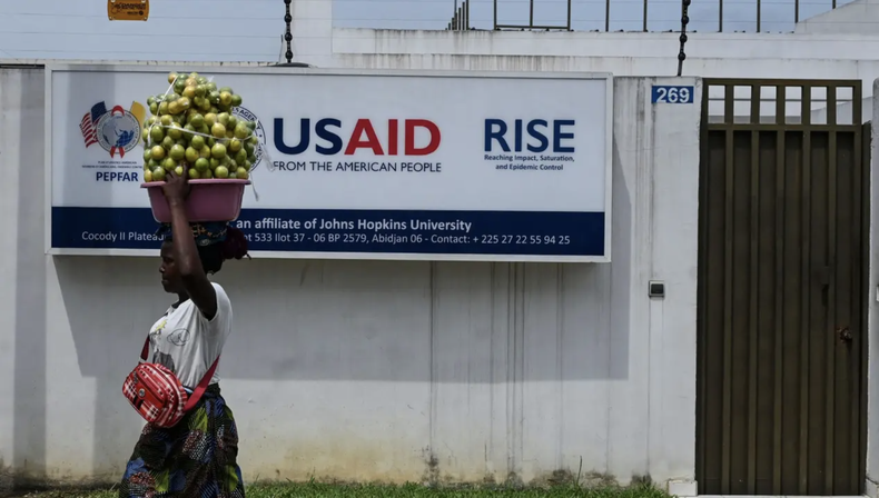 Una vendedora ambulante pasa frente a la oficina de la Agencia de los Estados Unidos para el Desarrollo Internacional (USAID) en Abiyán, 22 de marzo de 2025