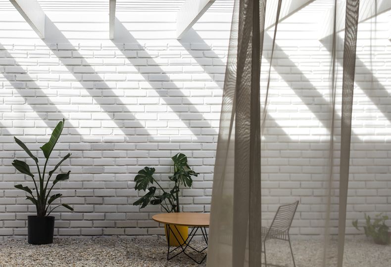 La galería exterior brinda continuidad al gran ambiente que conforma el espacio central del hogar. Algunos de los elementos que aparecen en este patio son la poltrona Prado y la mesa de centro Bezel, ambos de estudio Claro. Fotos: Marcos Guiponi