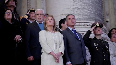 Carolina Cosse junto a Yamandú Orsi presenciando el arreo de los pabellones nacionales.