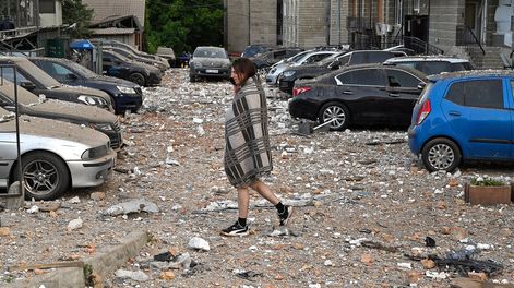 Búsqueda | Residente camina entre autos dañados al salir de un edificio parcialmente destruido después de ataques con drones en Kiev. Foto: Oleksandr Popenko, PIJL