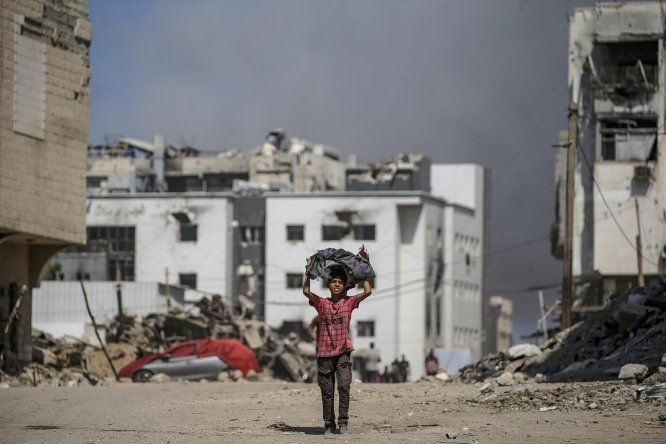 Un niño palestino camina mientras se eleva el humo tras un ataque aéreo israelí cerca del hospital Al-Shifa en la ciudad de Gaza, Franja de Gaza, el 28 de setiembre de 2025.&nbsp;