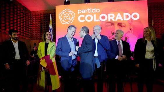 Los seis precandidatos y Diego Delgrossi, maestro de ceremonias, en la sala de convenciones del Partido Colorado. Foto: Javier Calvelo, adhocFOTOS