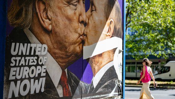 Una mujer pasa junto a un cartel que aboga por la creación de los Estados Unidos de Europa, en el que aparecen el presidente estadounidense Donald Trump y el presidente ruso Vladimir Putin besándose. Una mujer pasa junto a un cartel que aboga por la creación de los Estados Unidos de Europa, en el que aparecen el presidente estadounidense Donald Trump y el presidente ruso Vladimir Putin besándose.