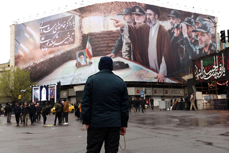 Un miembro de las fuerzas de seguridad iraníes monta guardia frente a una valla publicitaria que muestra al Líder Supremo iraní, Mojtaba Khamenei, y a comandantes militares iraníes durante una manifestación para conmemorar el Día Internacional de Al-Quds en Teherán, Irán, el 13 de marzo de 2026.&nbsp;