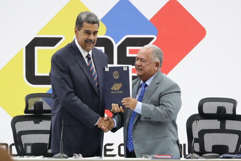 El presidente de Venezuela, Nicolás Maduro (i), y el presidente de Consejo Nacional Electoral (CNE), Elvis Amoroso, sostienen el acta de juramentación del presidente electo este lunes, en Caracas (Venezuela)