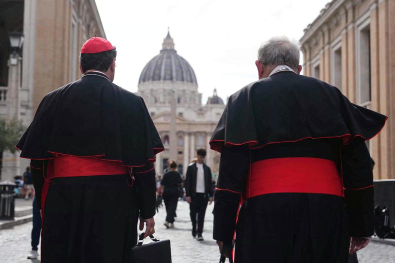 Dos cardenales caminan cerca del Vaticano, con la Basílica de San Pedro al fondo, en Roma, el 5 de mayo de 2025