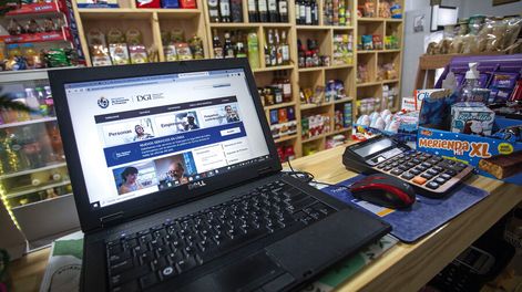 Laptop en el mostrador de un supermercado barrial de Montevideo. Foto: Nicolás Garrido / Búsqueda