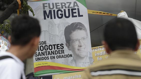 Personas observan carteles en un altar improvisado frente a la Fundación Santa Fe, lugar donde permanece hospitalizado el senador colombiano Miguel Uribe Turbay en Bogotá (Colombia)