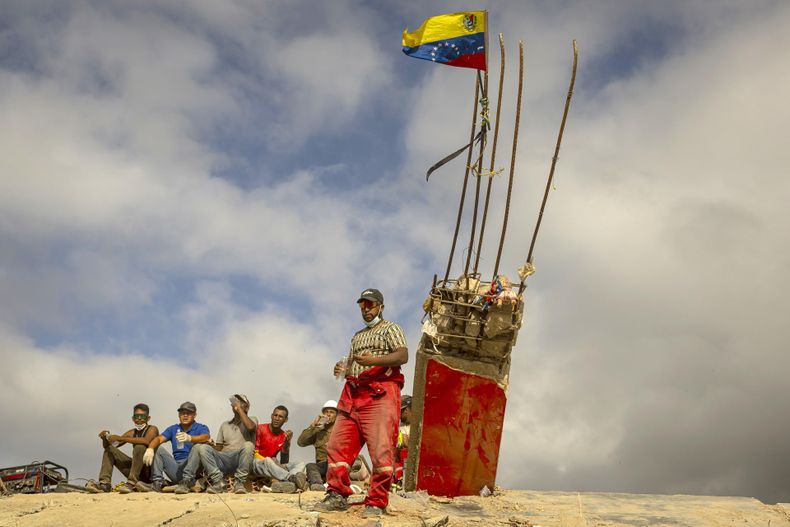Fotografía del 17 de julio del 2026 que muestra personas descansando durante un recorrido para acompañar con oraciones a familiares, voluntarios y rescatistas que continúan las labores de recuperación de cuerpos atrapados bajo los escombros tras los terremotos del pasado 24 de junio en Venezuela.