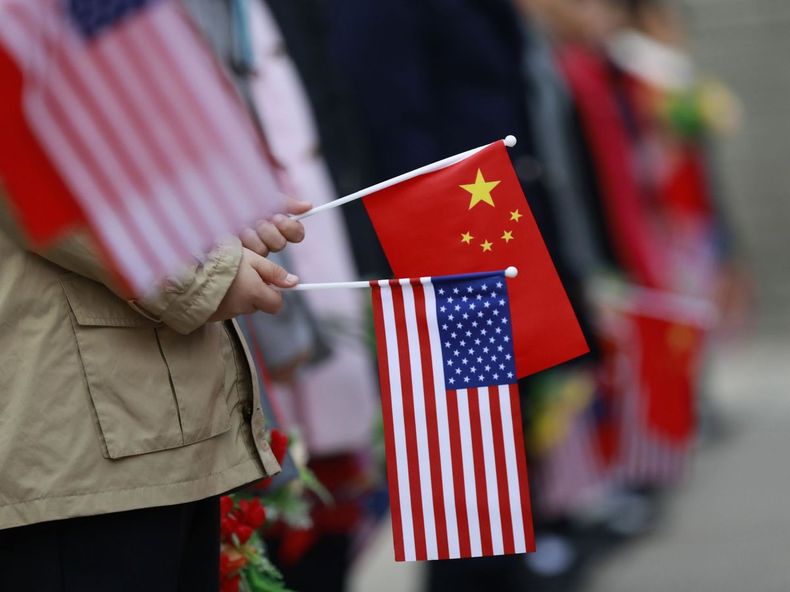 Niños que sostienen banderas de Estados Unidos y China