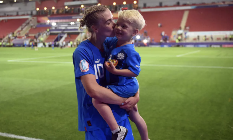 La centrocampista islandesa Dagny Brynjarsdottir besa a su hijo Brynjar al final del partido de fútbol del Grupo D de la Eurocopa 2022 entre Islandia y Francia en el Estadio de Nueva York en Rotherham, norte de Inglaterra, el 18 de julio de 2022