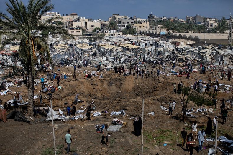 Palestinos desplazados inspeccionan los daños tras un ataque israelí en el campamento de Al-Manasrah, que albergaba a más de 200 familias en Deir al-Balah, en el centro de la Franja de Gaza, 21 de agosto de 2025.