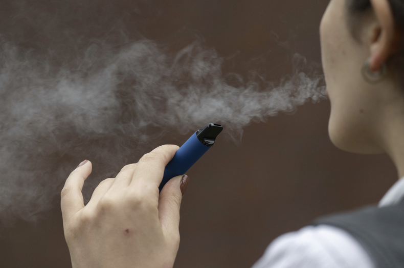 Una mujer fuma un cigarrillo electrónico