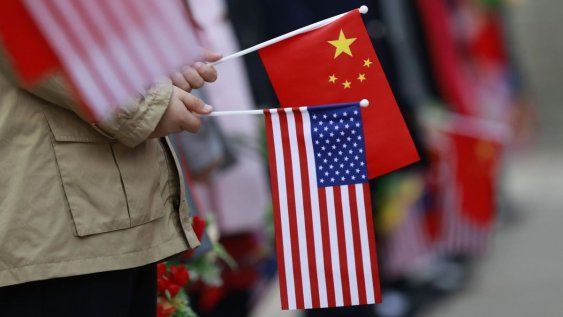 Niños que sostienen banderas de Estados Unidos y China Niños que sostienen banderas de Estados Unidos y China