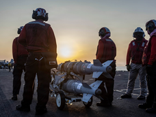 Marineros de Estados Unidos preparan municiones en la cubierta de vuelo del portaaviones USS Abraham Lincoln, de la clase Nimitz, mientras navega por las aguas de Medio Oriente.