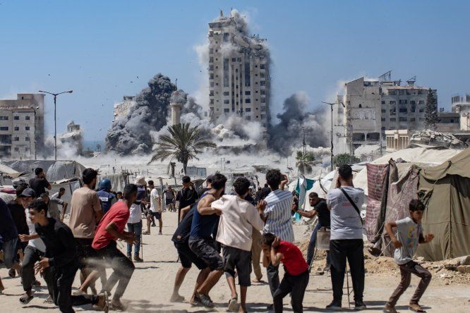Palestinos reaccionan al humo que se eleva desde la Torre Mushtaha tras un ataque aéreo israelí en el oeste de la ciudad de Gaza, Franja de Gaza, el 5 de setiembre de 2025.