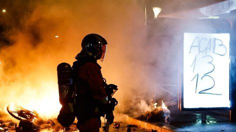 Un bombero francés acude a sofocar el incendio de una barricada en París, Francia, el 18 de octubre de 2026, en el marco de los enfrentamientos entre la policía antidisturbios y los manifestantes.