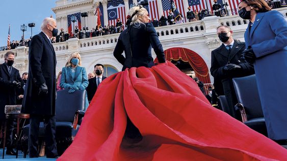 Lady Gaga llevó un vestido de Schiparelli Couture con una voluminosa pollera roja y una chaqueta de cashemere azul marino, tonos elegidos para hacer honor a la bandera estadounidense.