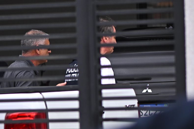 El expresidente brasileño Jair Bolsonaro (d) llega a su casa tras salir de alta del hospital este viernes, en Brasilia (Brasil). Bolsonaro, condenado por tramar un golpe de Estado, recibió el alta tras dos semanas ingresado por una neumonía aguda y comenzó a cumplir 90 días de prisión domiciliaria por orden de la Corte Suprema.