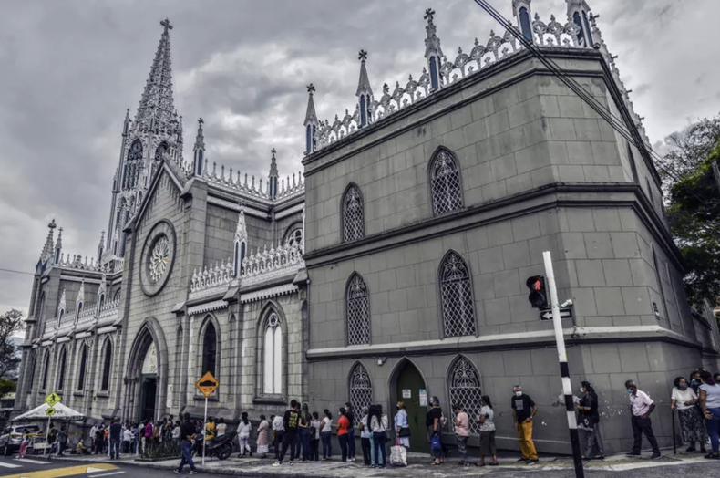 Fieles católicos hacen cola para entrar en la Iglesia de Manrique para asistir a la tradicional misa de Jueves Santo en Medellín, Colombia, el 1 de abril de 2021
