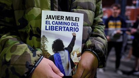 Simpatizante de Milei con el libro que publicó el economista en 2022. Foto: Luis Robayo, AFP