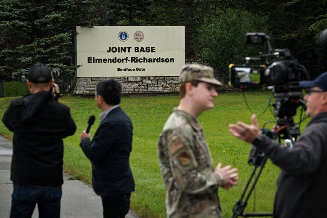 Periodistas trabajan cerca de una entrada a la Base Conjunta Elmendorf-Richardson en Anchorage, Alaska, antes de la reunión entre Donald Trump y Vladimir Putin