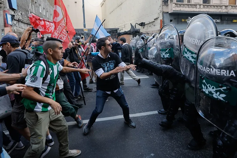 Manifestantes y miembros de la Gendarmería Nacional se enfrentan este miércoles, durante una manifestación frente al Congreso de la Nación en Buenos Aires.