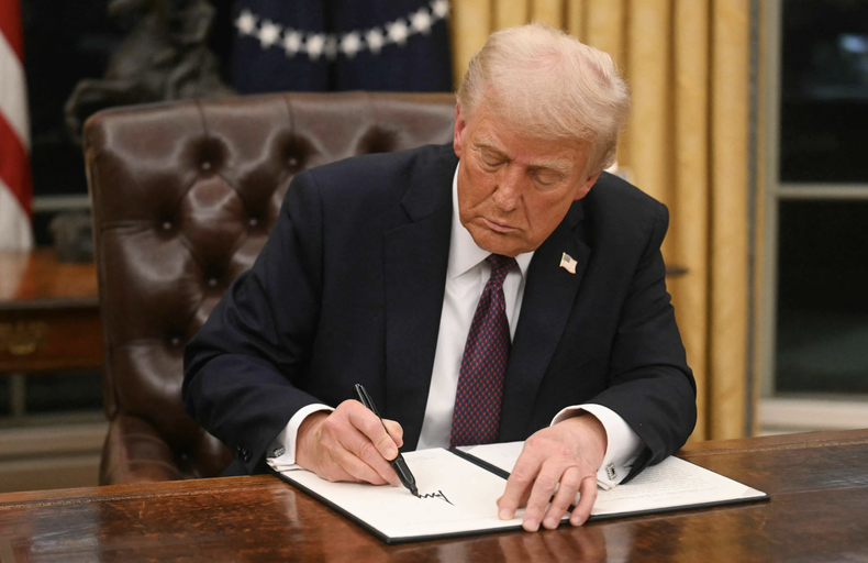Donald Trump firma una orden ejecutiva en la Oficina Oval de la Casa Blanca.
