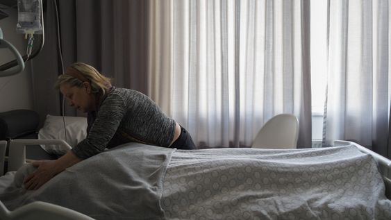 La cuidadora Marie-Josee Rousseaux ajusta la manta sobre el cuerpo de Lydie Imhoff después del proceso de eutanasia en un hospital de Bélgica, el 1º de febrero de 2024.