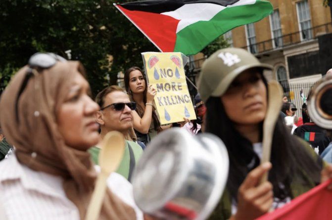 Manifestantes propalestinos sostienen pancartas y banderas frente a Downing Street, Londres.