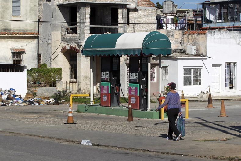 Una persona camina frente a una estación de servicio cerrada por falta de combustible este lunes, en La Habana (Cuba).