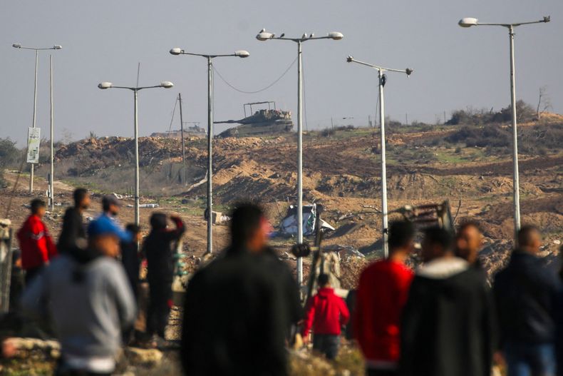 Un tanque del ejército israelí toma posición mientras los gazatíes desplazados cruzan el corredor de Netzarim desde el sur de la Franja de Gaza&nbsp;