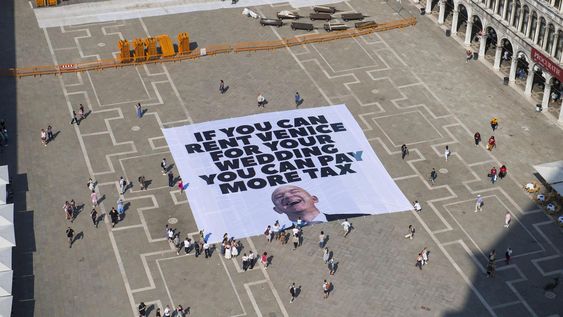 Una fotografía facilitada por la oficina de prensa de Greenpeace muestra a activistas del grupo ambiental Greenpeace desplegando una pancarta gigante con la imagen del empresario estadounidense y fundador de Amazon, Jeff Bezos, y un eslogan que dice Si puedes alquilar Venecia para tu boda, puedes pagar más impuestos en la Plaza de San Marcos en Venecia, Italia, el 23 de junio de 2025 Una fotografía facilitada por la oficina de prensa de Greenpeace muestra a activistas del grupo ambiental Greenpeace desplegando una pancarta gigante con la imagen del empresario estadounidense y fundador de Amazon, Jeff Bezos, y un eslogan que dice Si puedes alquilar Venecia para tu boda, puedes pagar más impuestos en la Plaza de San Marcos en Venecia, Italia, el 23 de junio de 2025