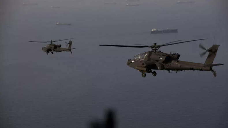 Esta fotografía, difundida por el Mando Central de Estados Unidos el 18 de abril de 2026, muestra helicópteros Apache sobrevolando el estrecho de Ormuz.