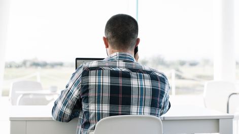 Búsqueda | back-man-working-front-laptop-talking-mobile