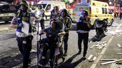 Una mujer herida es evacuada en silla de ruedas en una zona impactada por un misil lanzado desde Irán, en Ramat Gan, cerca de Tel Aviv, el 13 de junio de 2025