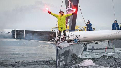 Mientras atracaba, el francés Charles Caudrelier sostuvo dos bengalas tras ganar el Desafío Arkea, la primera regata de navegación en solitario alrededor del mundo. AFP 