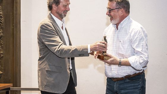 El presidente de la Cámara Uruguaya del Libro, Álvaro Risso, entrega a Fernando Butazzoni el premio a la Trayectoria,.
