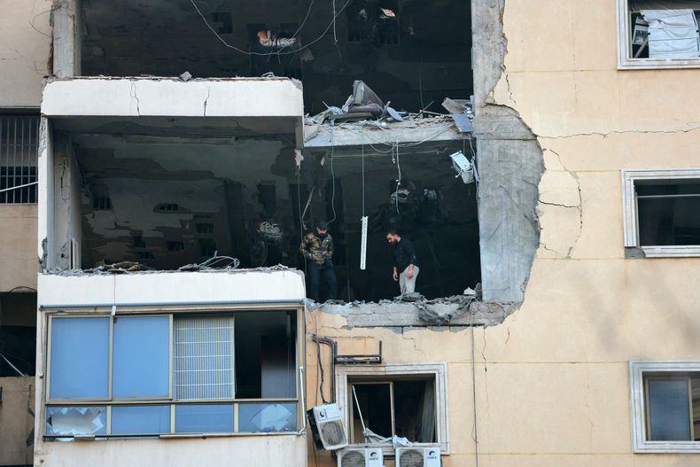 La gente inspecciona un edificio dañado después de un ataque aéreo israelí en el barrio de Haret Hreik, en el sur de Beirut, el 2 de marzo de 2026.