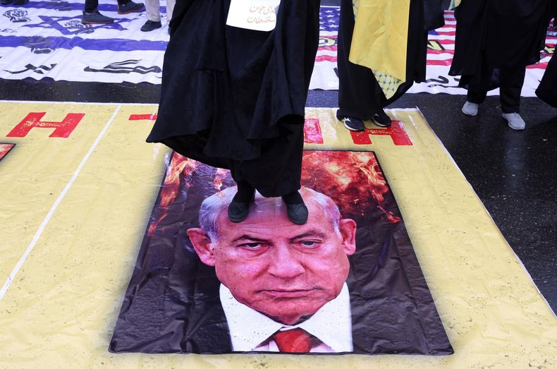 Ciudadanos iraníes pisotean un cartel con la imagen del primer ministro israelí, Benjamin Netanyahu, durante una manifestación para conmemorar el Día Internacional de Al-Quds en Teherán, Irán, el 13 de marzo de 2026.&nbsp;