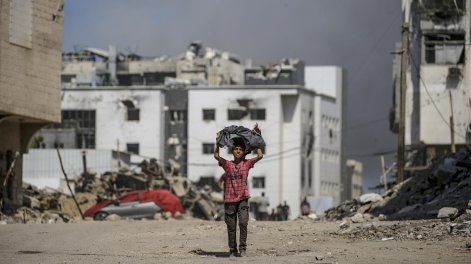 Un niño palestino camina mientras se eleva el humo tras un ataque aéreo israelí cerca del hospital Al-Shifa en la ciudad de Gaza, Franja de Gaza, el 28 de setiembre de 2025. 