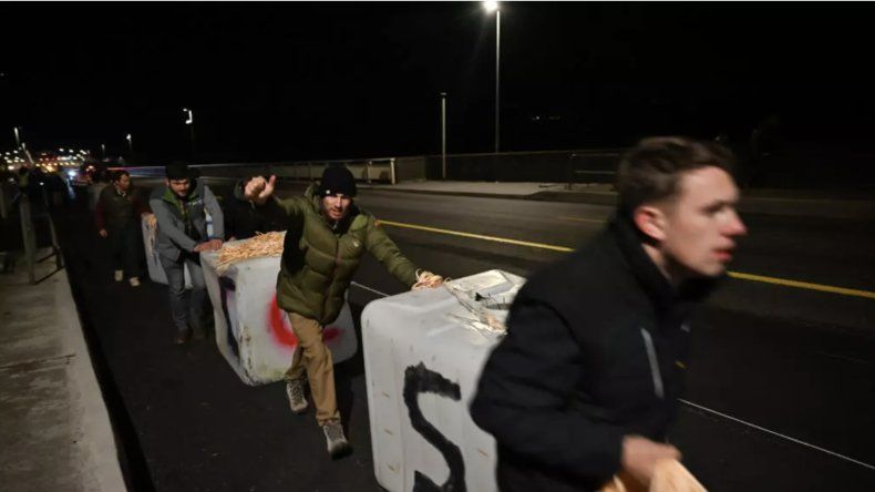 Unos detractores del acuerdo Unión Europea-Mercosur cuelgan unos bidones de agua del Puente de Tancarville, en Francia, durante una protesta el 26 de noviembre de 2025.