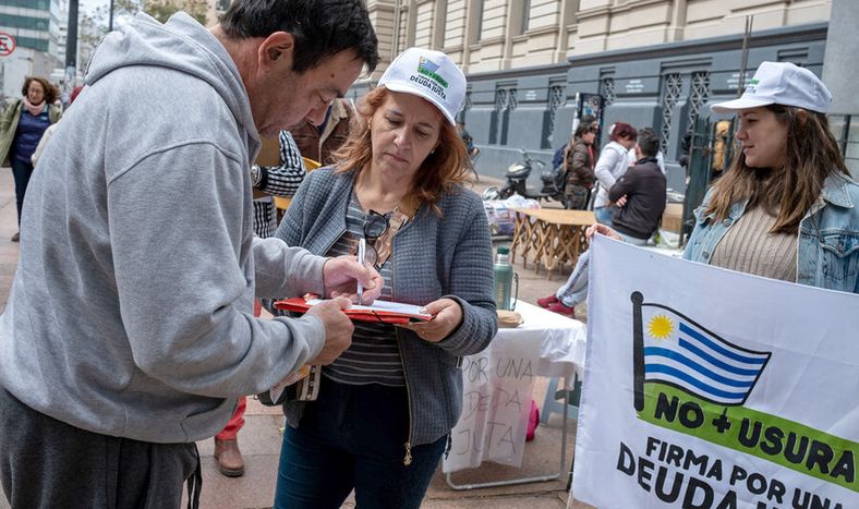 Militantes del plebiscito No más Usura-Por una Deuda Justa, impulsado por el partido Cabildo Abierto, recogen firmas en Av. 18 de Julio. Foto: Ricardo Antúnez