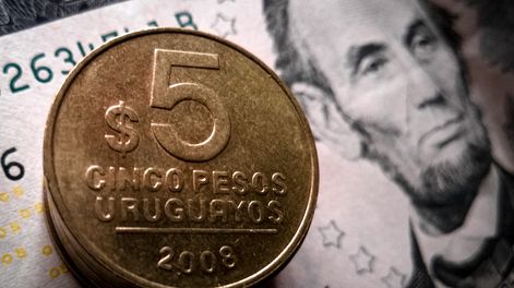 Monedas de peso uruguayo y dólares.