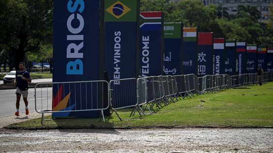Un hombre corre junto a las pancartas de la cumbre BRICS en los alrededores del Museo de Arte Moderno (MAM), donde se celebrará la cumbre BRICS 2025 en Río de Janeiro