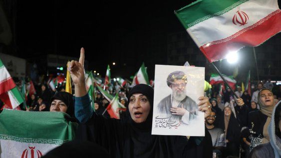 Una mujer sostiene una fotografía del difunto Líder Supremo, el ayatolá Ali Khamenei, mientras la gente se reúne durante una manifestación tras el ataque iraní contra Israel, en la plaza Valiasr de Teherán, Irán, el 7 de junio de 2026.