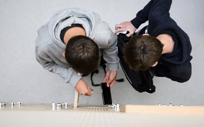 Alumnos guardan sus teléfonos celulares en sus taquillas tras apagarlos, durante una prueba en un colegio de Lorient, al oeste de Francia.